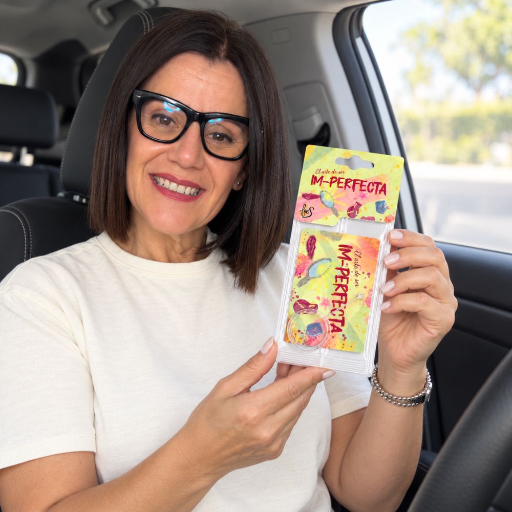 Mari Carmen, CEO y fundadora de D'Arome, mostrando el ambientador de coche Im-Perfecta de LoeS sentada al volante – D'Arome