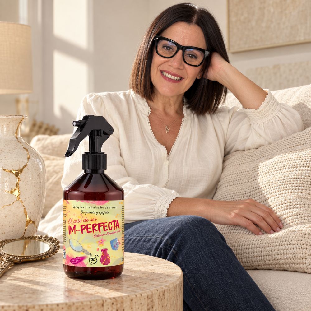 Mari Carmen, CEO y fundadora de D'Arome, relajada en su salón con el spray textil Im-Perfecta de LoeS sobre la mesa de centro – D'Arome
