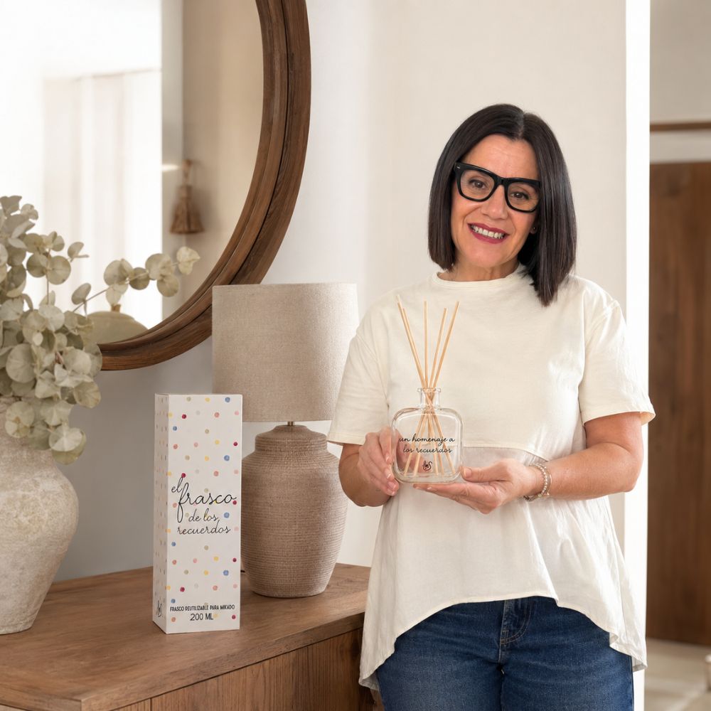 Mari Carmen, CEO y experta en aromas de D'Arome, sosteniendo el envase mikado reutilizable 200ml "Un homenaje a los recuerdos" de LoeS junto a su caja decorativa – D'Arome