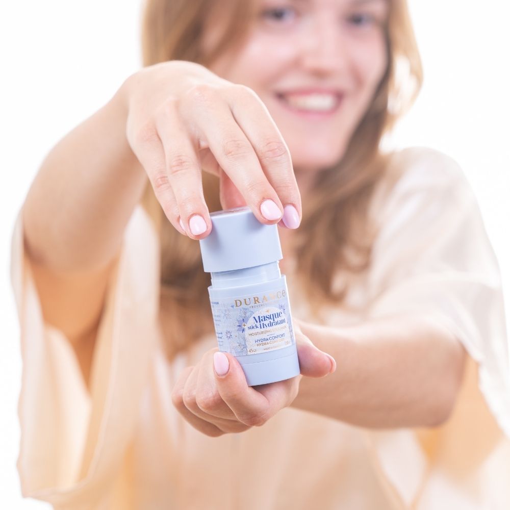 Abriendo el tapón de la mascarilla hidratante en stick con aceite de borraja Durance, gesto de aplicación hacia cámara – D'Arome