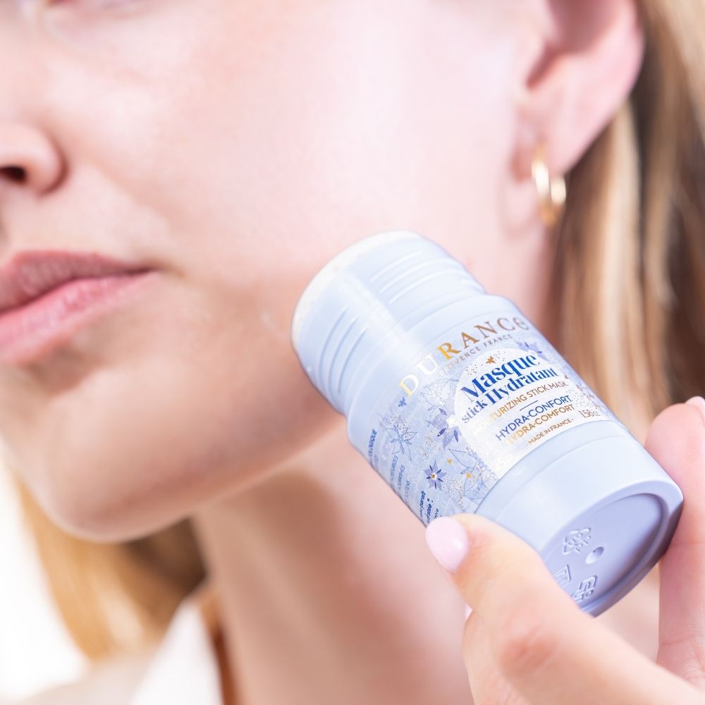 Aplicando la mascarilla hidratante en stick con aceite de borraja Durance directamente sobre la mejilla en primer plano – D'Arome