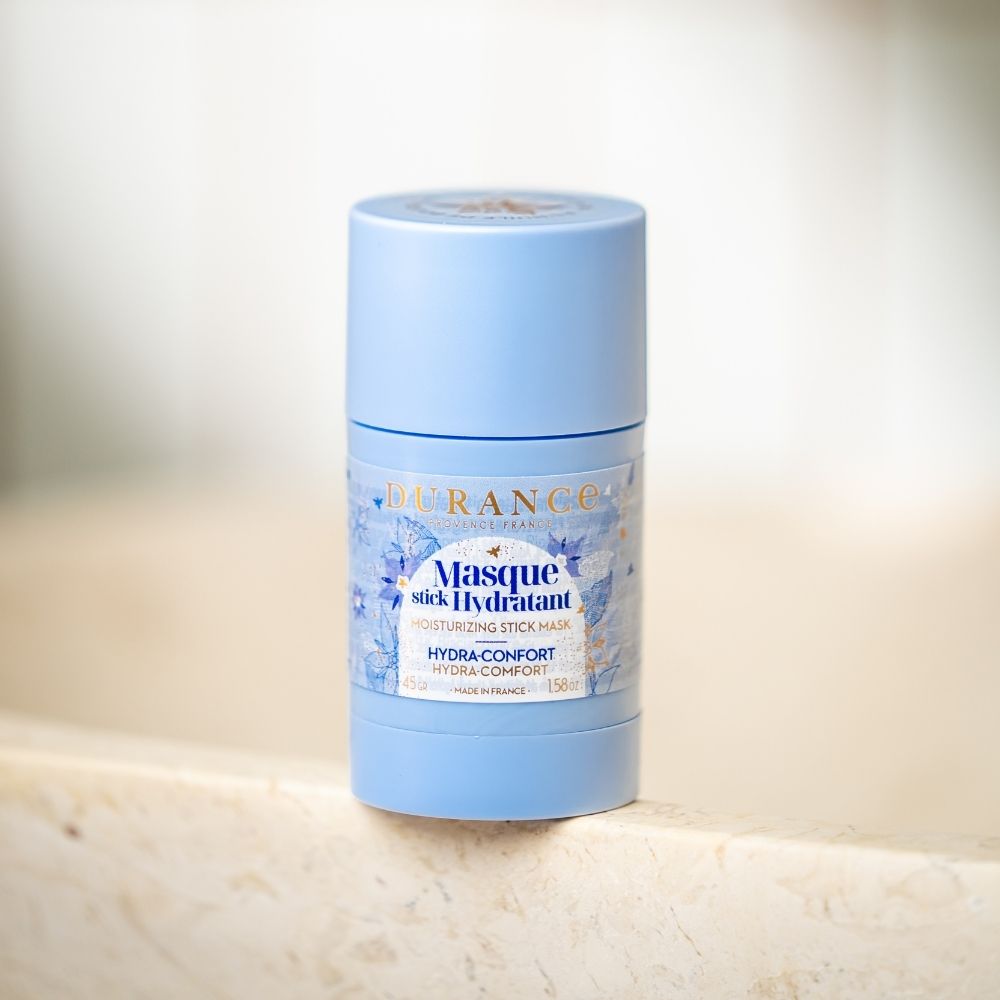 Mascarilla hidratante en stick con aceite de borraja Durance apoyada sobre el borde de un lavabo de mármol – D'Arome