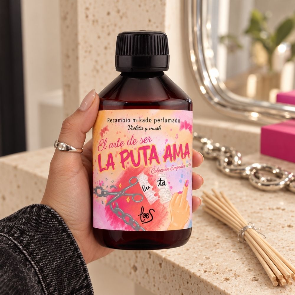 Mano sujetando el recambio de mikado perfumado La Puta Ama de LoeS de 500 ml, la opción de ahorro para tener aroma a violeta y musk todo el año – D’Arome