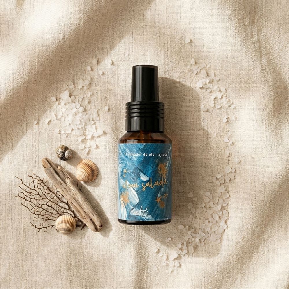 Mini spray textil Alma Salada de LoeS de 50 ml en plano cenital con sal marina, conchas y madera flotante sobre lino natural – D'Arome