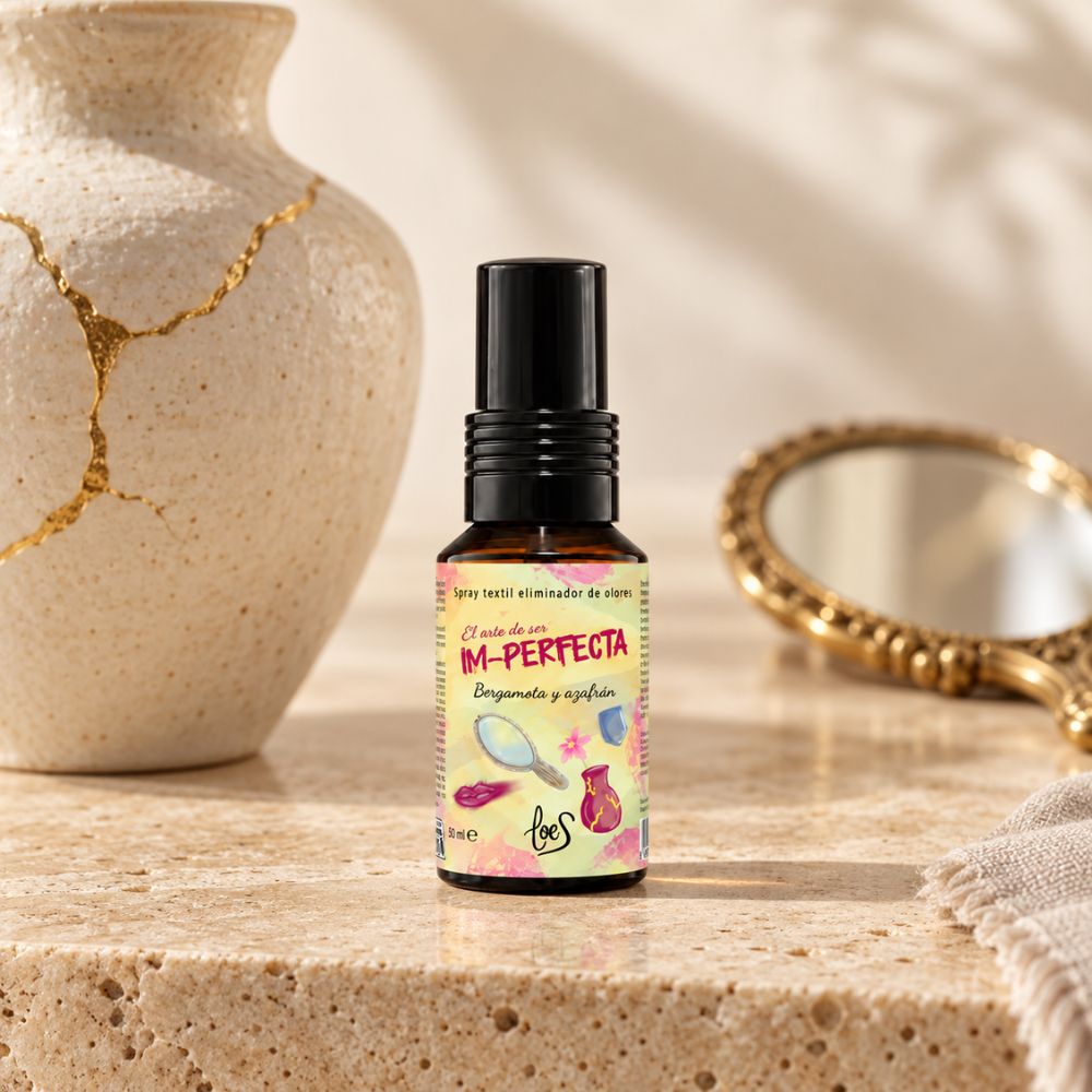 Mini spray textil eliminador de olores Im-Perfecta de LoeS de 50 ml, junto a un jarrón de cerámica reparado con kintsugi, símbolo de las grietas que también son belleza – D'Arome