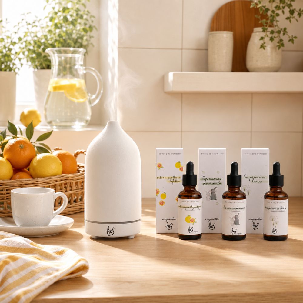 Pack tres esencias cítricas LoeS con brumizador cerámico encendido junto a jarra de limonada casera y cesto de naranjas en cocina soleada – D'Arome