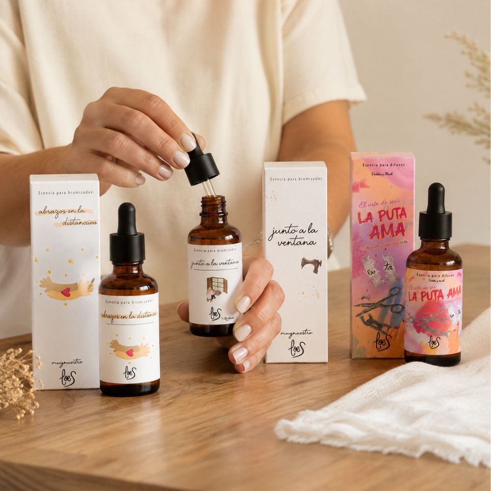 Demostración de uso del pack de aromas orientales LoeS con las manos sosteniendo el cuentagotas de la esencia Junto a la Ventana sobre mesa de madera, cómo se usa la esencia para difusor – D'Arome