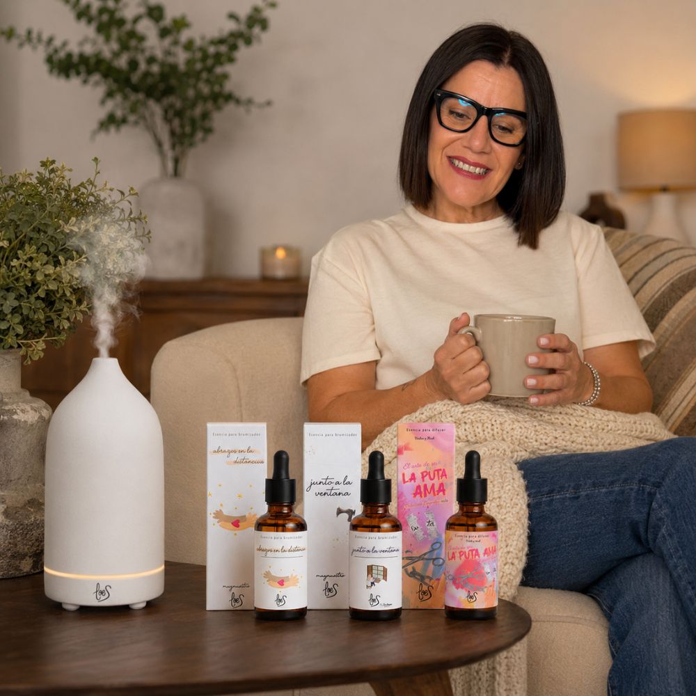 María Carmen, CEO de D'Arome, disfrutando del pack de aromas orientales LoeS junto al difusor de cerámica blanca LoeS encendido en el sofá con una taza humeante – D'Arome
