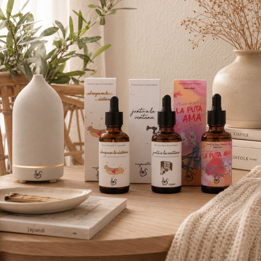 Pack de aromas orientales LoeS junto al difusor de cerámica blanca LoeS sobre mesa de madera con libros y rama de olivo en ambiente zen – D'Arome
