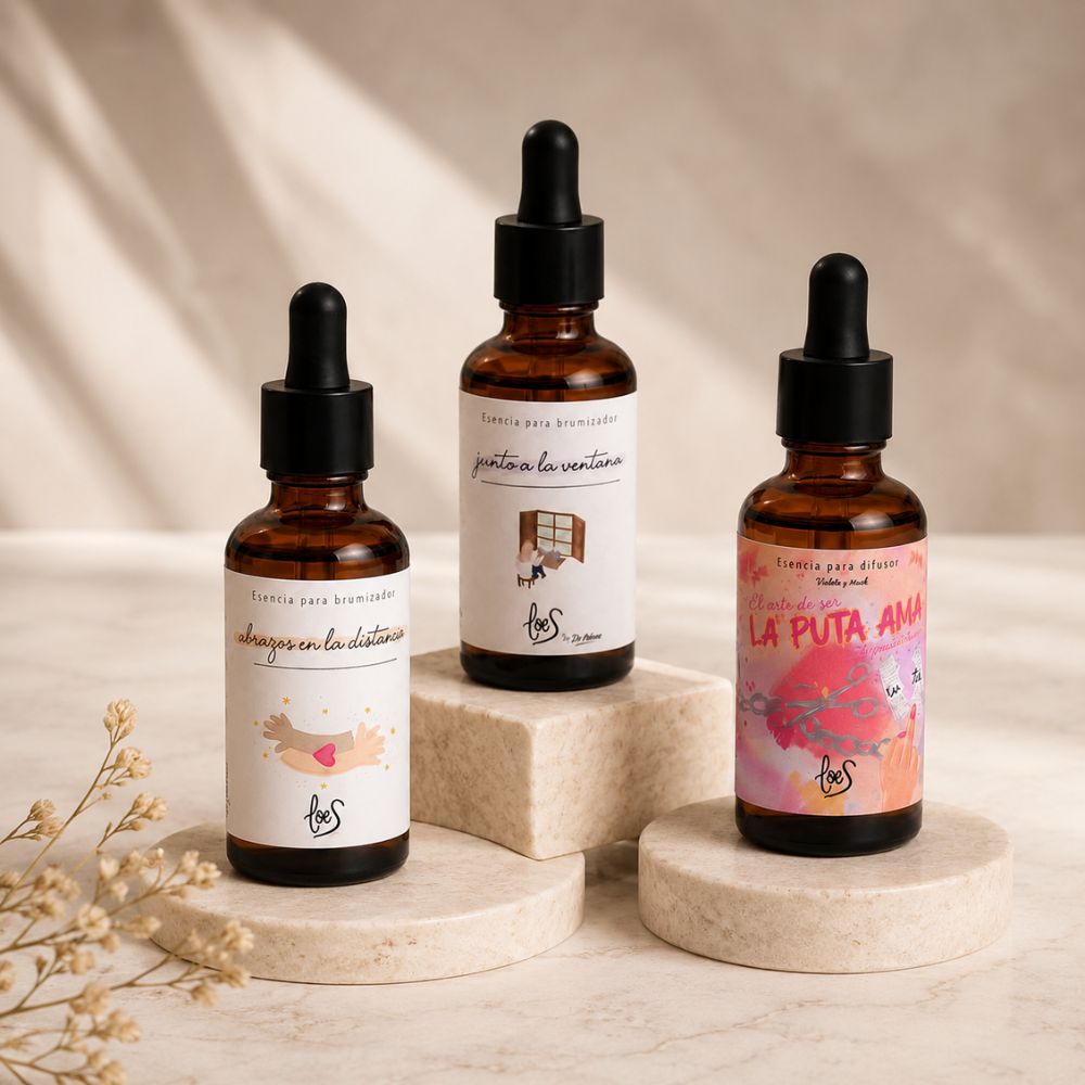 Pack de aromas orientales LoeS con las tres esencias para difusor Abrazos en la Distancia, Junto a la Ventana y La Puta Ama sobre podios de piedra clara en composición editorial – D'Arome