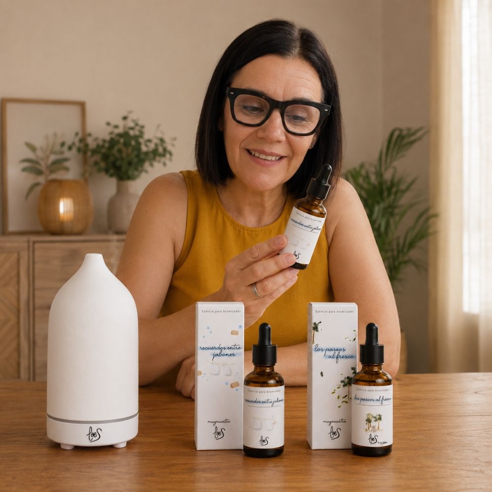 La fundadora Mari Carmen sonriendo junto al pack de dos esencias más vendidas de Loes y un difusor de aroma con vapor.
