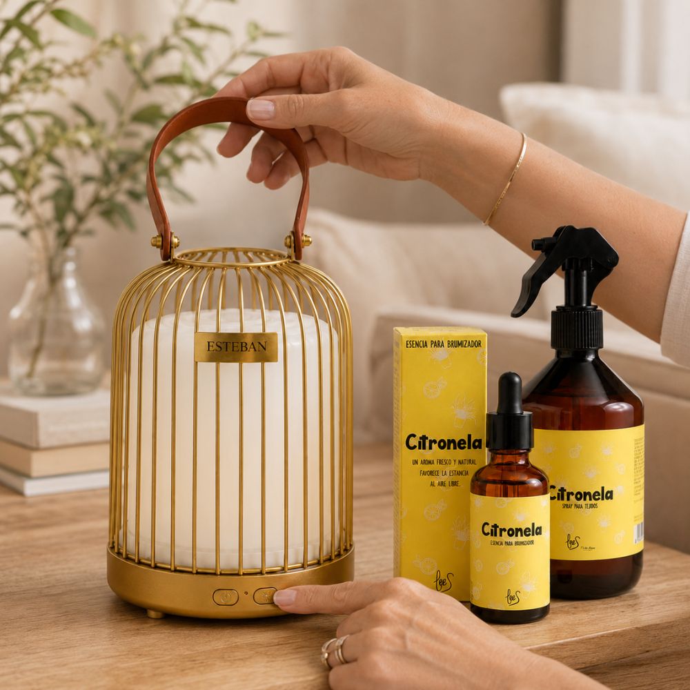 Manos sujetando el difusor inalámbrico farol Esteban dorado por el asa de cuero con pack citronela LoeS, ambientador anti-mosquitos portátil – D'Arome