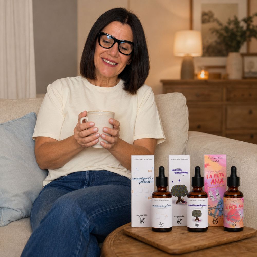Mari Carmen, embajadora de D'Arome, disfrutando del pack top ventas de tres esencias para difusor LoeS con una taza humeante en el sofá, momento de calma – D'Arome