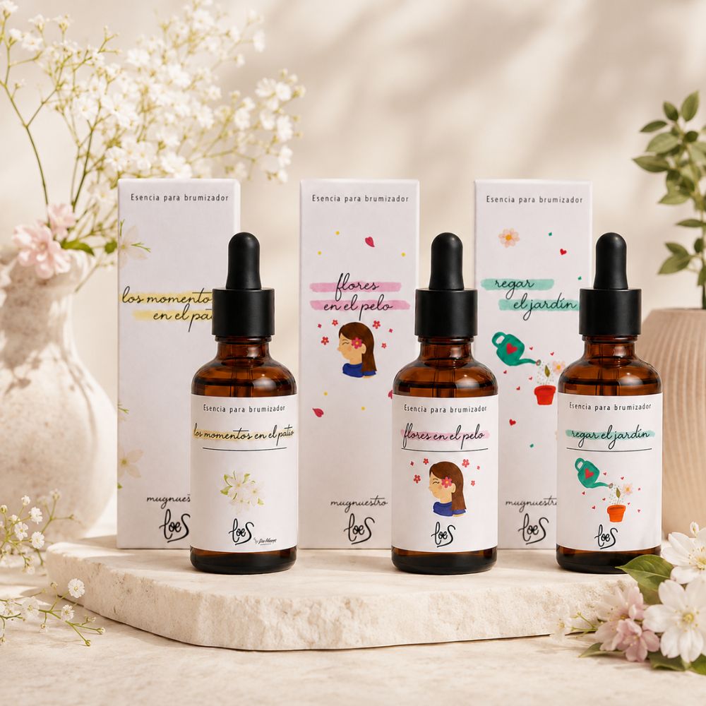 Pack de tres aromas florales LoeS para difusor de perfume con cajas y frascos cuentagotas sobre piedra natural rodeado de paniculata y flores blancas – D'Arome