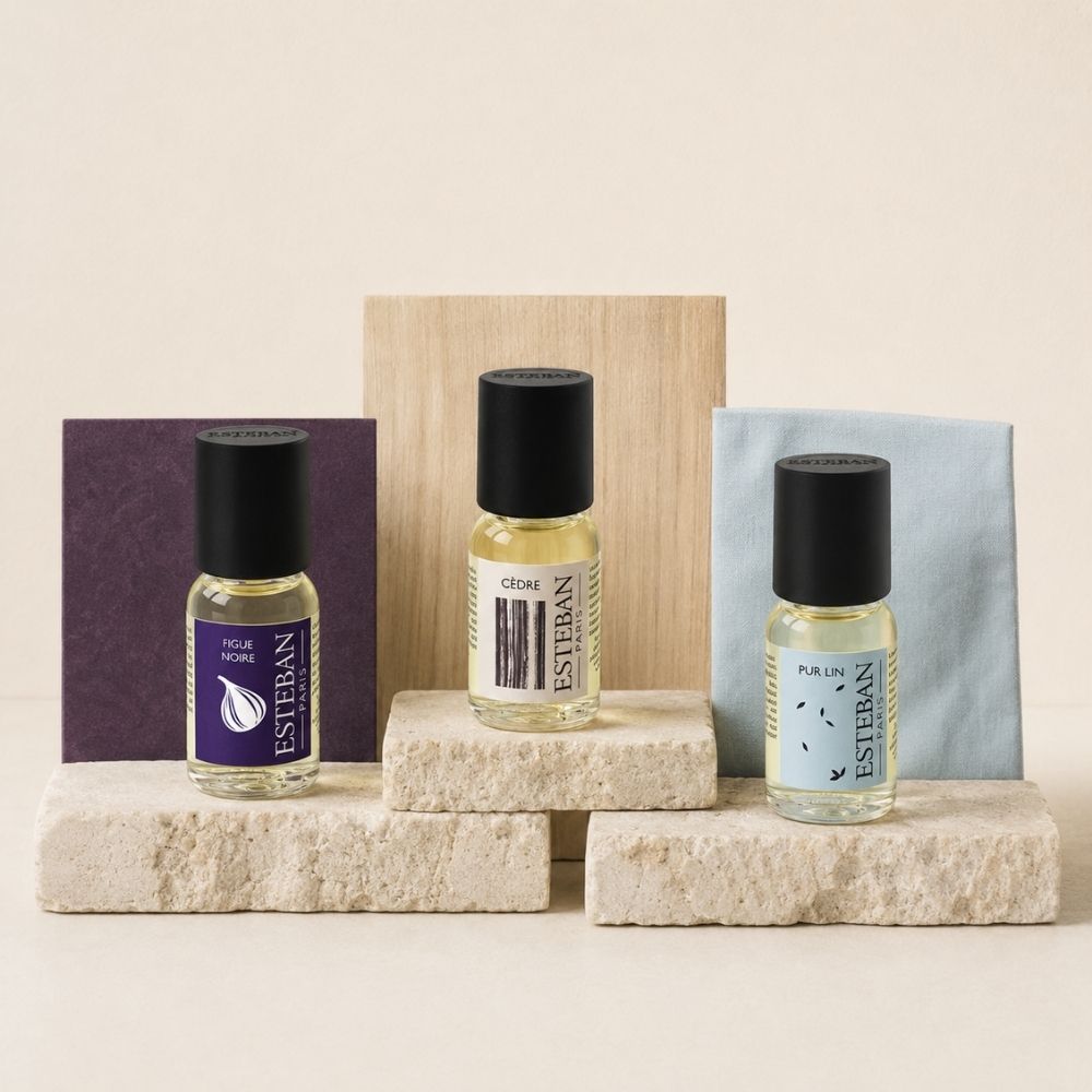 Los tres frascos de concentrado de perfume Figue Noire, Cèdre y Pur Lin Esteban París sobre bloques de piedra clara – D'Arome