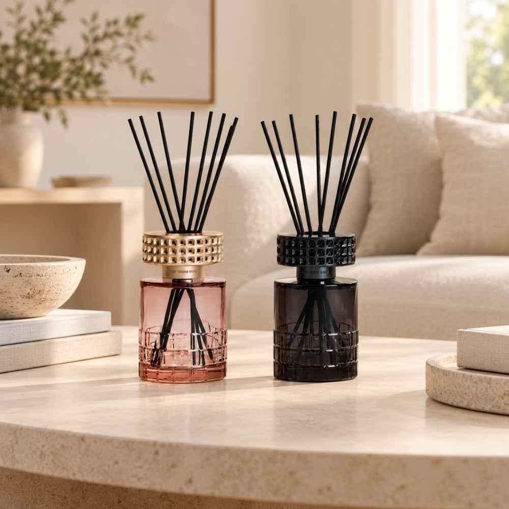 Pareja de Ambientadores Mikado Celebration Maison Berger en cristal rosa y negro sobre mesa de centro en salón – D'Arome
