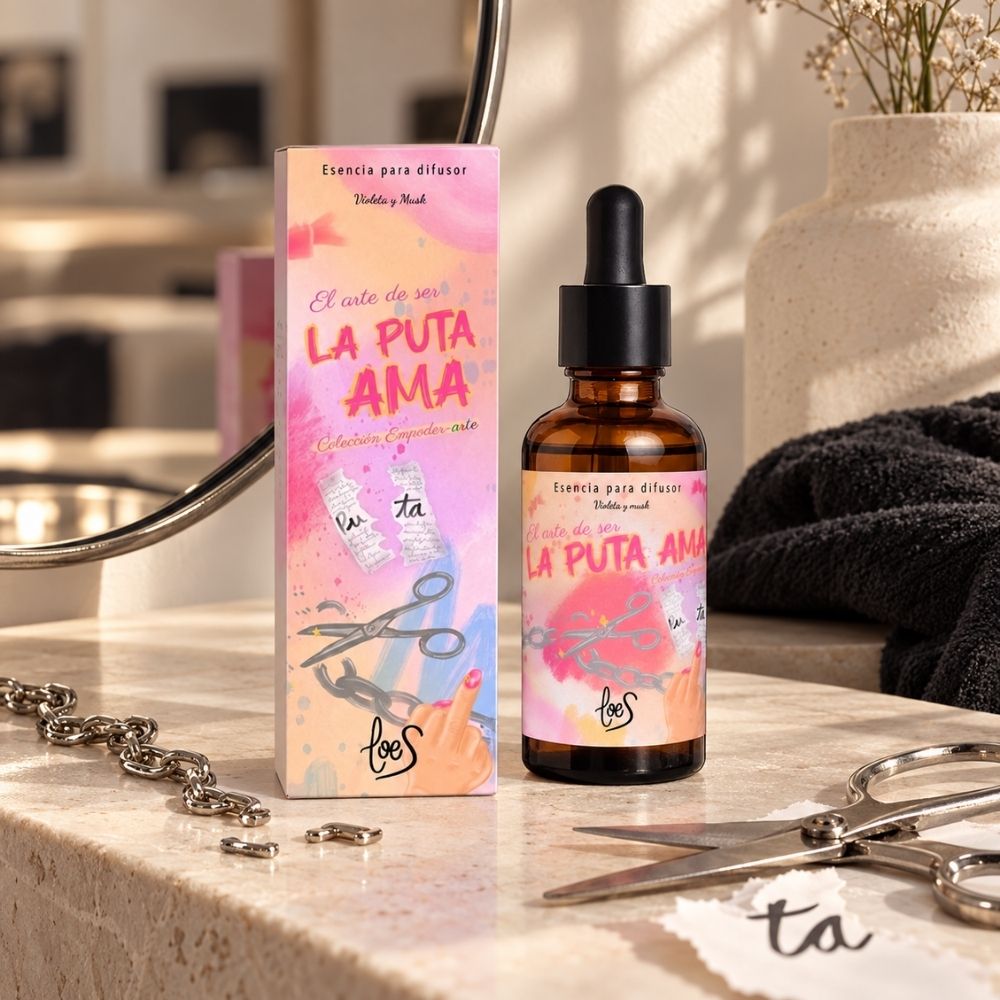 Perfume para difusor La Puta Ama de LoeS en el tocador del baño junto al papel recortado del packaging y unas tijeras, aroma de mujer que no pide permiso – D’Arome