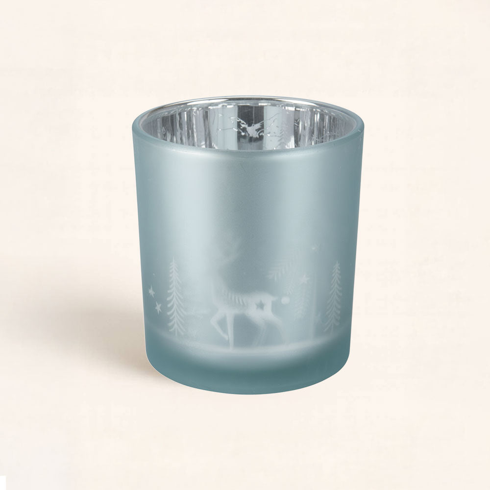 Portavelas Blanca Navidad Azul con diseño de renos y abetos. Luz suave y reflejos plateados para una decoración navideña elegante y acogedora.