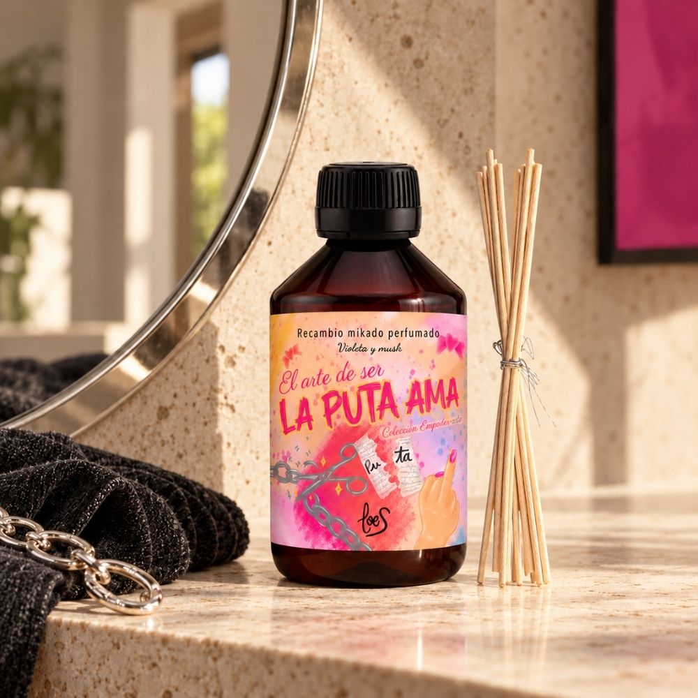 Recambio de ambientador de varillas La Puta Ama de LoeS de 500 ml junto al espejo del baño, con toalla negra y cadena de la colección Empoder-arte – D’Arome