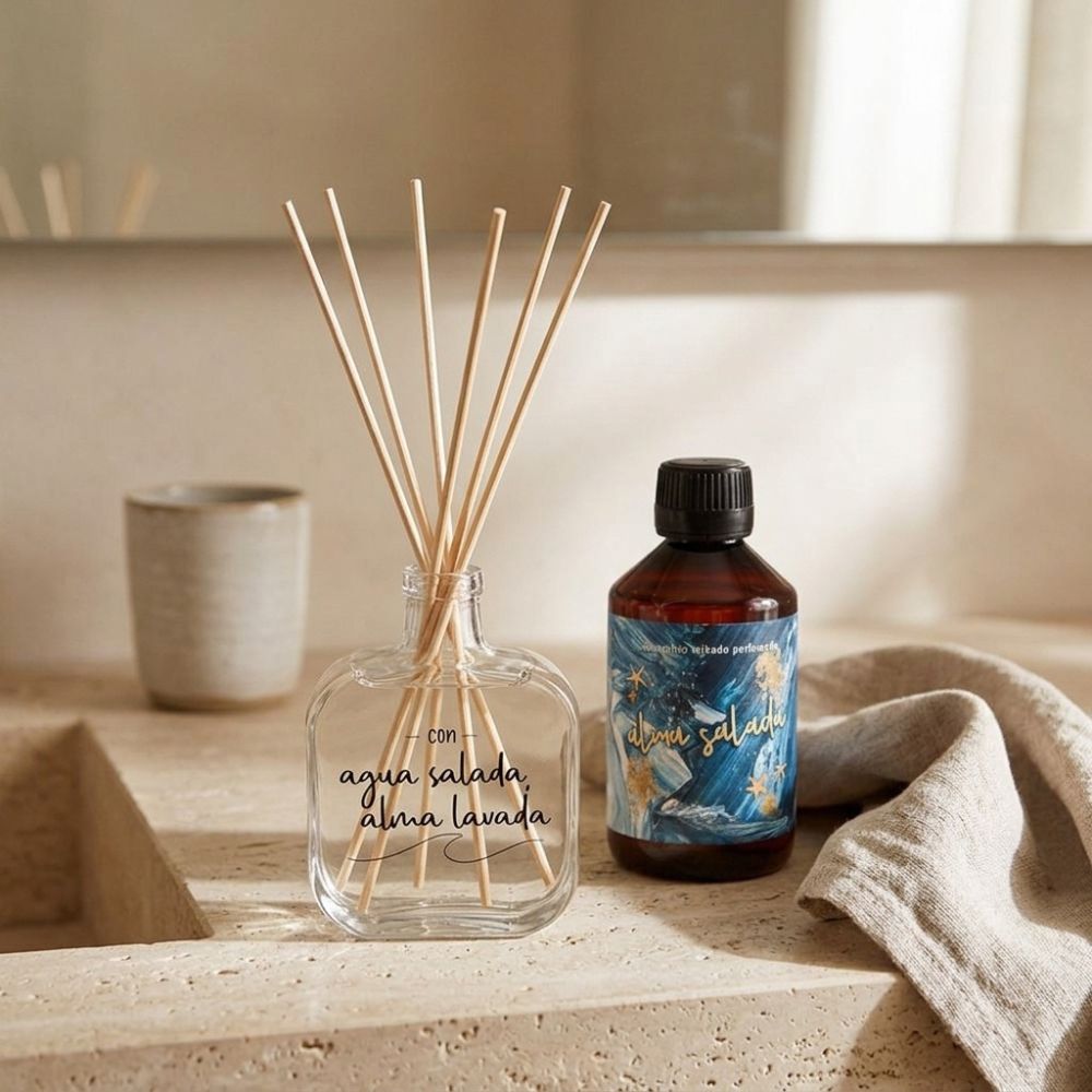 Ambientador Mikado perfumado Alma Salada de LoeS junto a su recambio de 250 ml sobre la encimera de piedra de un baño de inspiración mediterránea – D'Arome