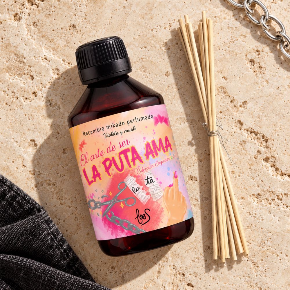 Recambio mikado La Puta Ama de LoeS, 250 ml, visto desde arriba sobre piedra natural con varillas de ratán, una cadena y tela vaquera negra – D’Arome