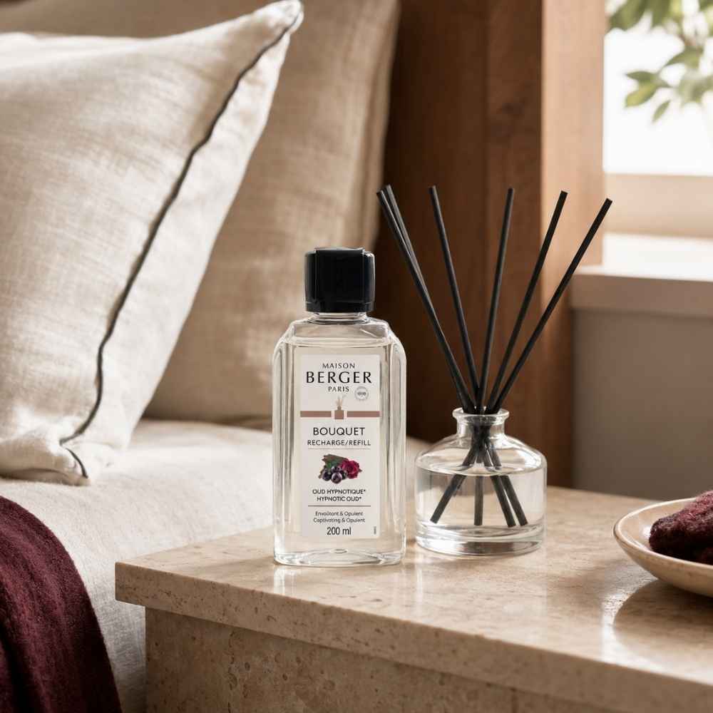 Recarga Bouquet Oud Hipnótico Maison Berger 200 ml junto a varillas de celulosa sobre mesilla de noche – D'Arome