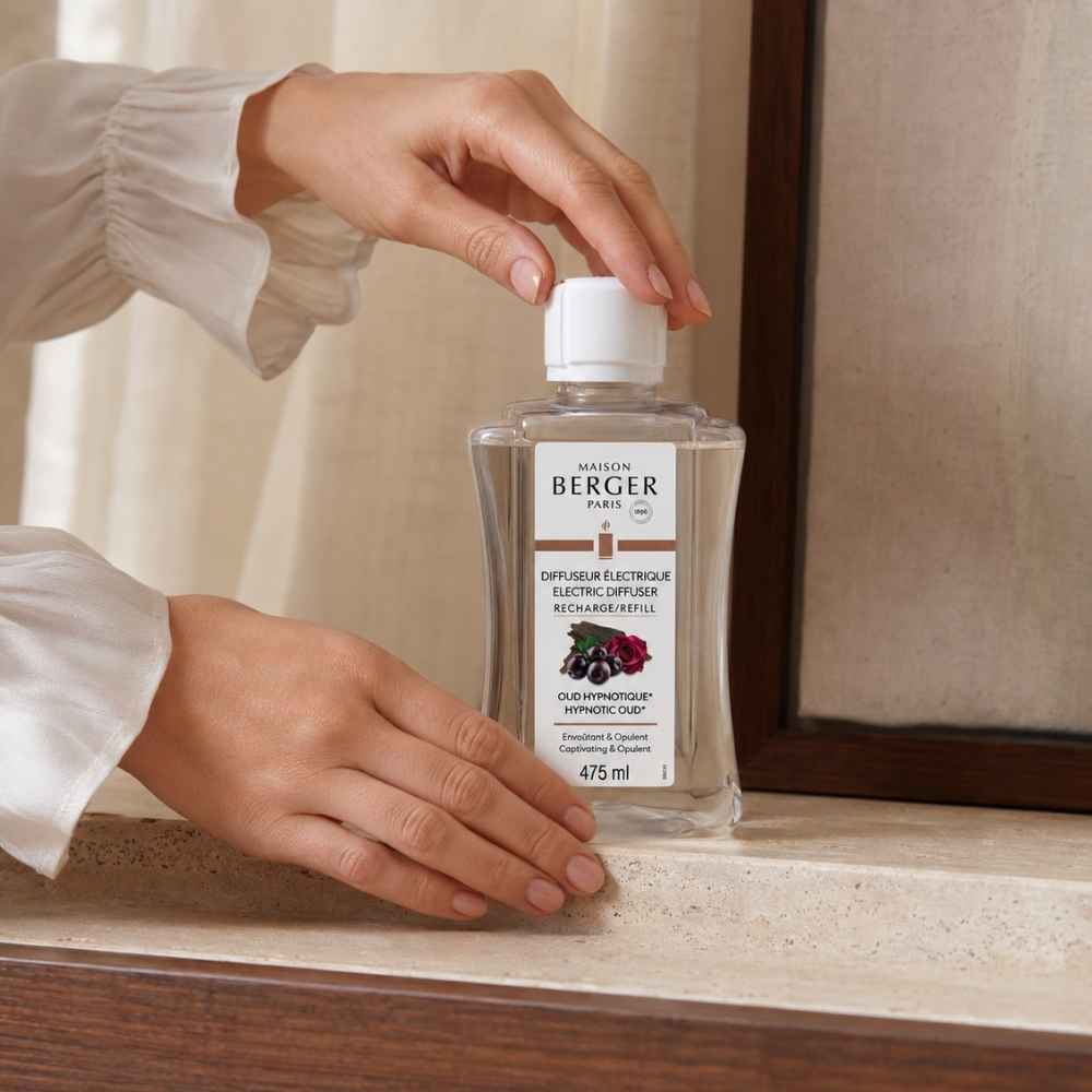 Detalle de manos abriendo la recarga de difusor eléctrico Oud Hipnótico Maison Berger 475 ml – D'Arome