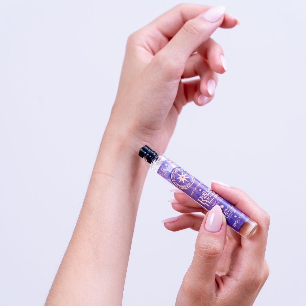Mujer aplicando el roll-on perfumado Rituel Détente de Durance en el antebrazo con ambas manos en primer plano – D'Arome