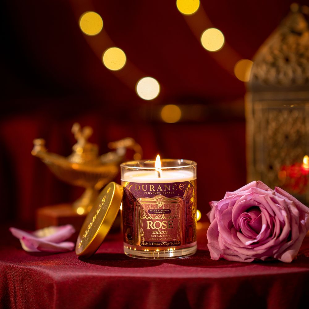 Ambientador spray Rosa Sultana 100ml de Durance junto a pétalos de rosa y lámpara árabe dorada, aroma oriental floral colección Una Navidad en la Ópera – D'Arome