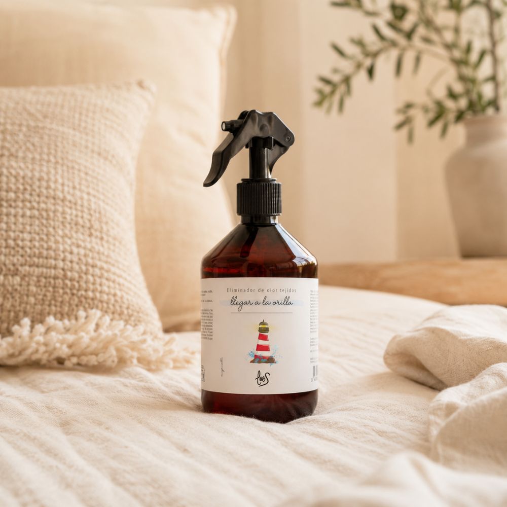 Spray textil eliminador de olor para tejidos Llegar a la Orilla de LoeS sobre cama vestida con ropa de cama de lino y cojín texturizado en dormitorio – D'Arome