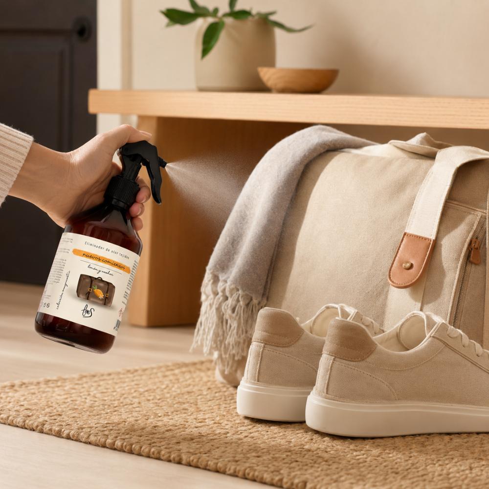 Spray textil eliminador de olores Nuevos Comienzos de LoeS con aroma a limón y azahar junto a zapatillas y bolso de viaje en recibidor – D'Arome