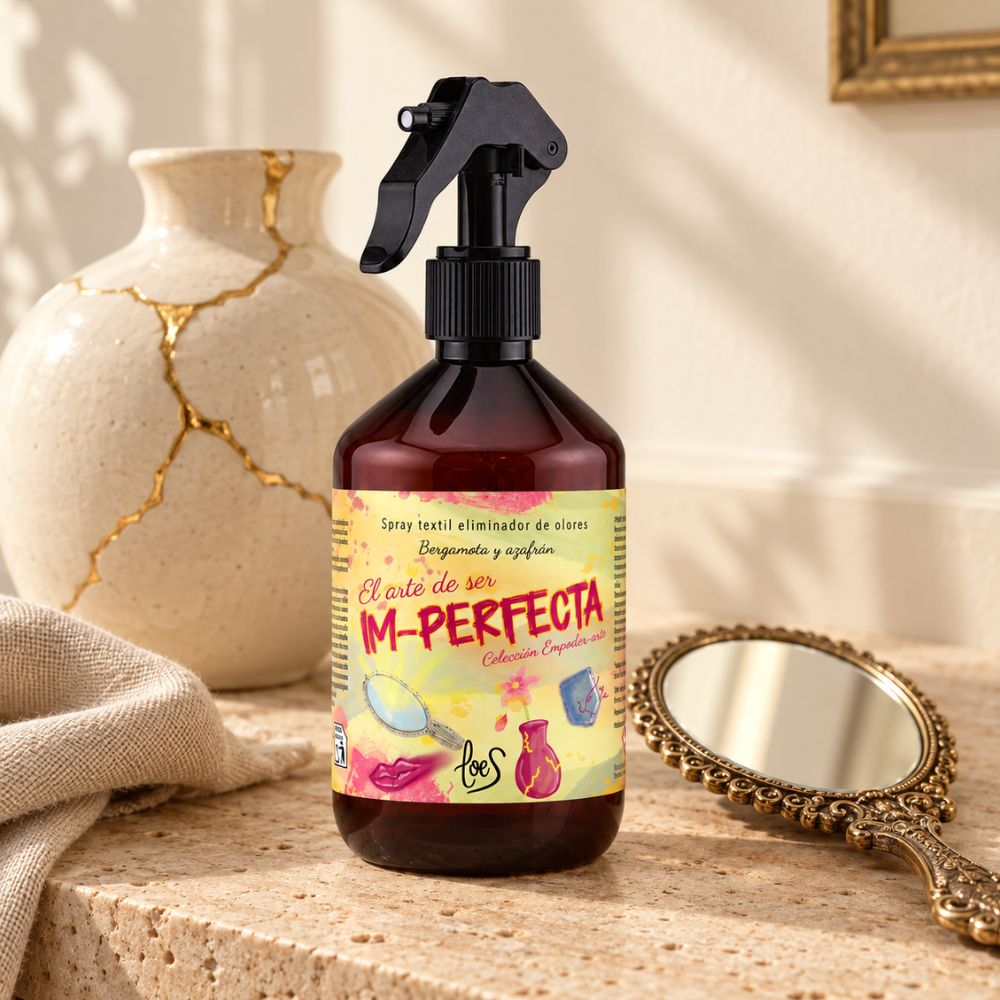 Spray textil eliminador de olores Im-Perfecta de LoeS de 500 ml, junto a un jarrón reparado con kintsugi y un espejo de mano antiguo sobre una cómoda – D'Arome