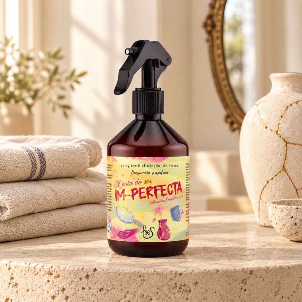 Bote de 500 ml del spray textil Im-Perfecta de LoeS junto a un montón de toallas de lino dobladas, listo para renovar cualquier tejido de casa – D'Arome