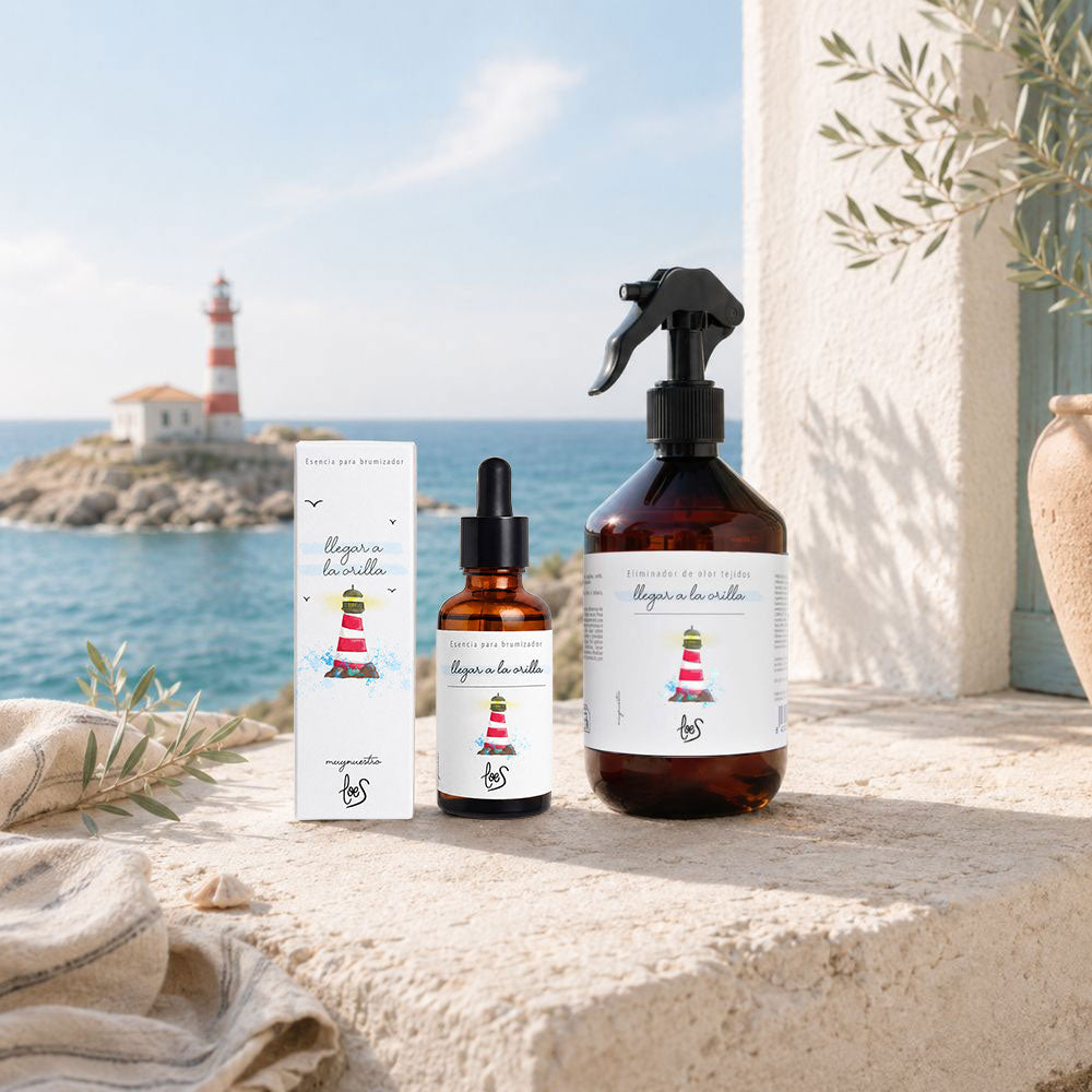 Bodegón de la colección Llegar a la Orilla de LoeS con esencia para difusor de aromas y spray textil eliminador de olores frente a un faro junto al mar – D'Arome
