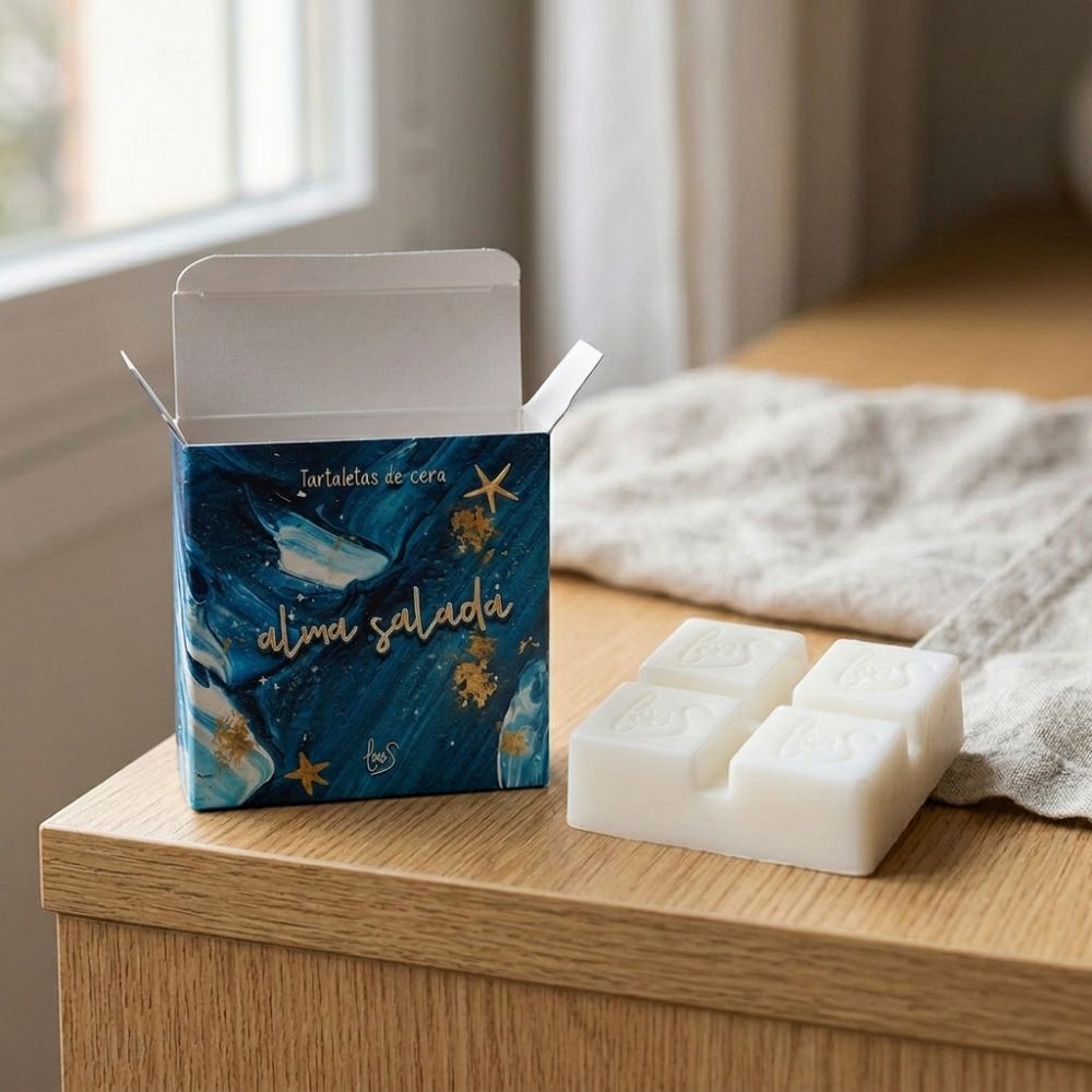 Caja abierta de tartaletas de cera Alma Salada de LoeS sobre un mueble de madera natural junto a sus cuatro cubos de cera blanca – D'Arome