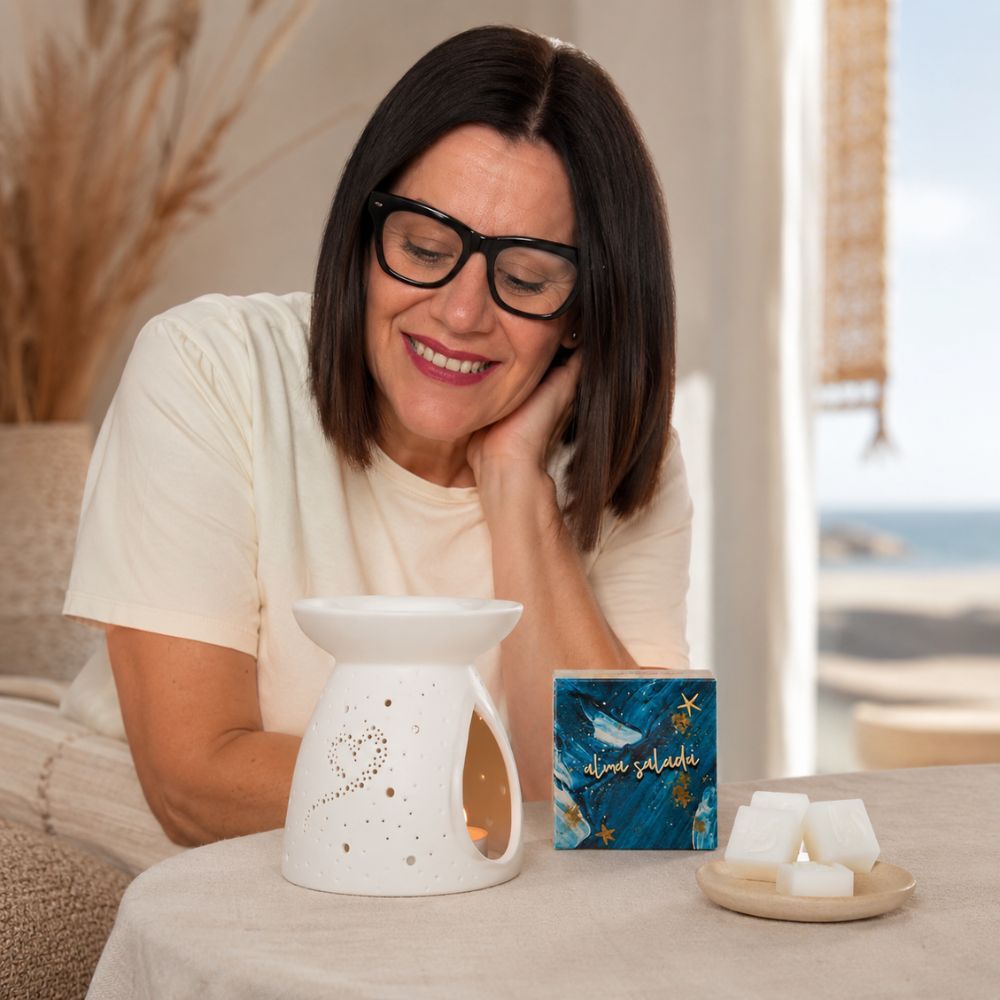 Marí Carmen, CEO y experta en aromas de D'Arome, enciende la vela tealight del quemador con una cerilla para derretir las tartaletas de cera Alma Salada de LoeS – D'Arome
