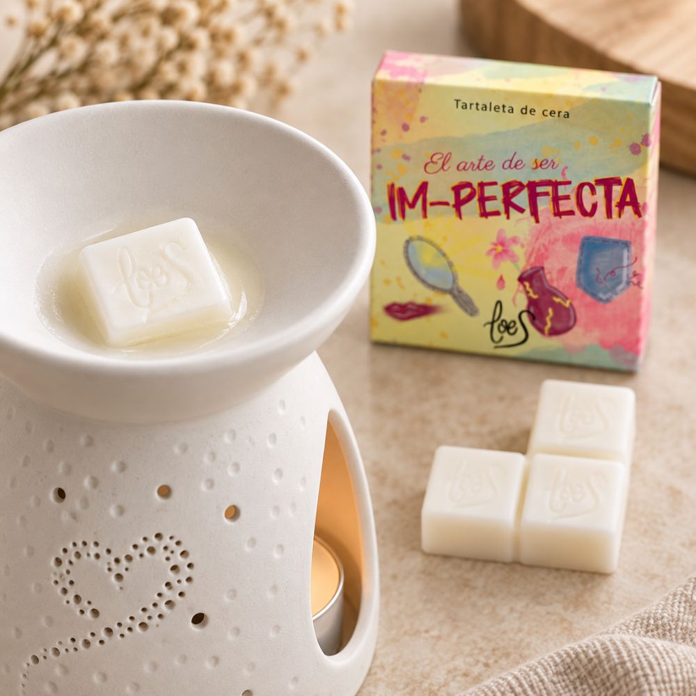 Cubo de la tartaleta de cera Im-Perfecta de LoeS derritiéndose en un quemador de cerámica con vela encendida – D'Arome