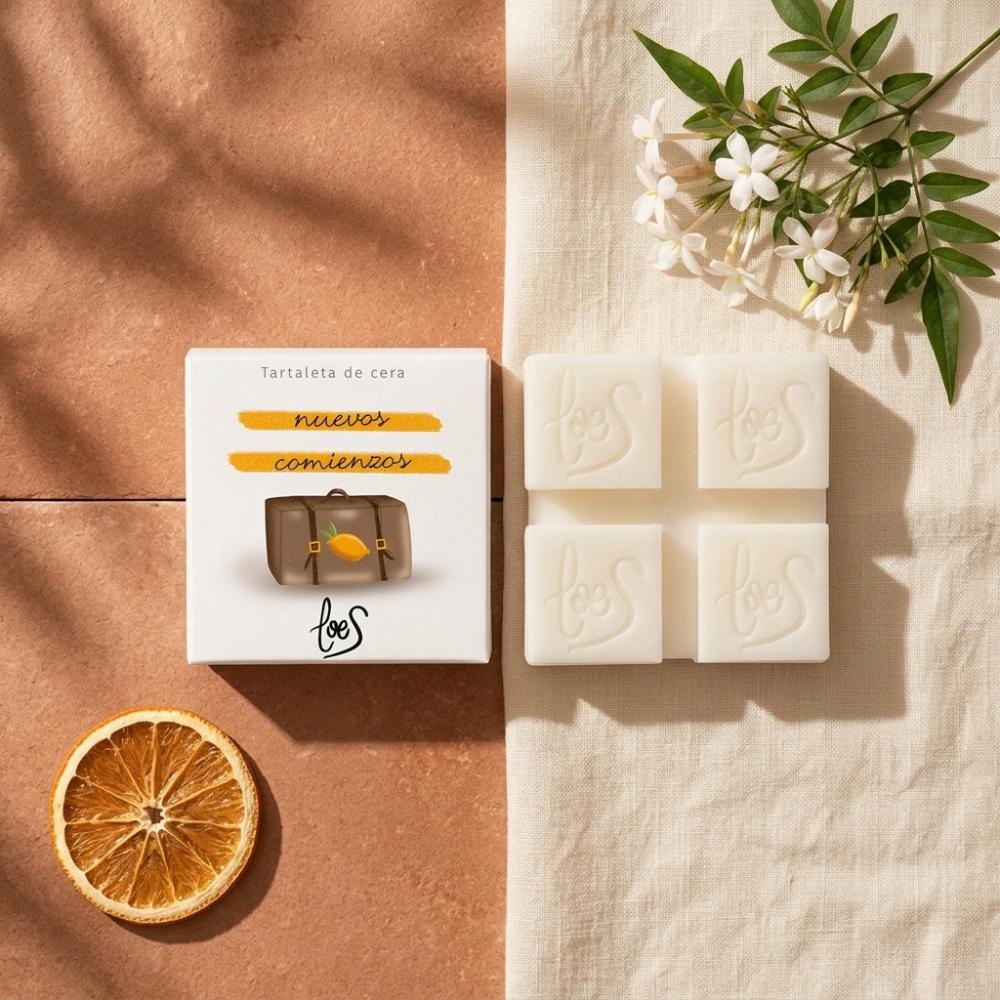 Tartaleta de cera Nuevos Comienzos LoeS limón y azahar con caja sobre fondo bicolor terracota y lino, naranja seca y flores de azahar – D'Arome