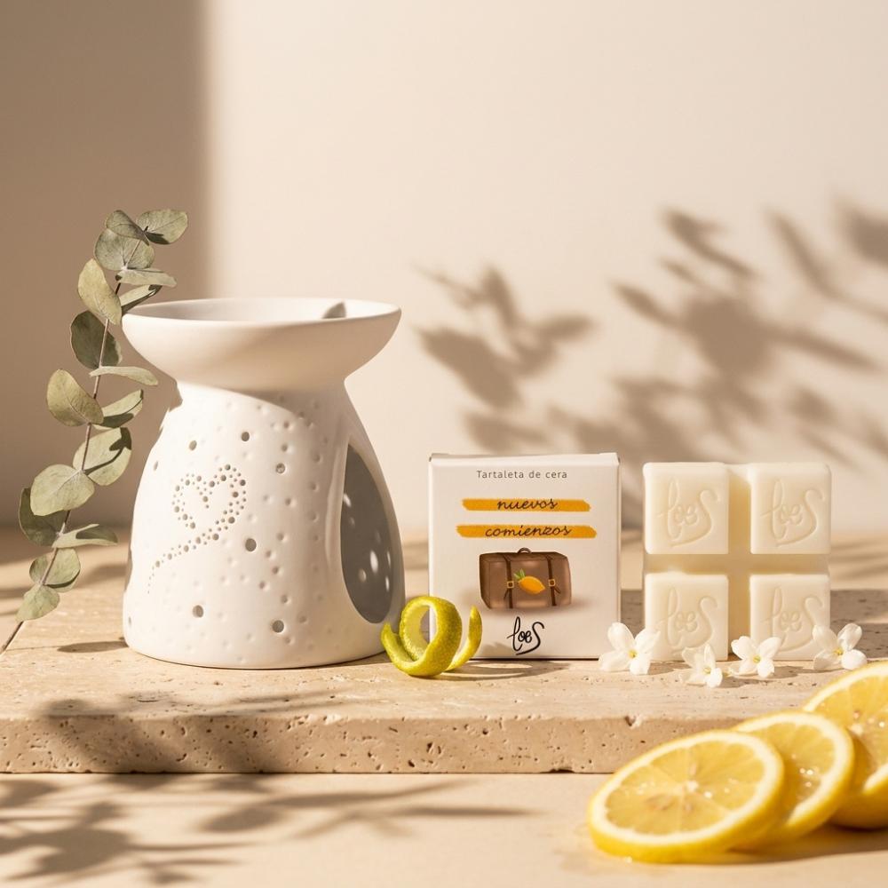 Quemador cerámico blanco con tartaleta de cera Nuevos Comienzos LoeS limón y azahar, caja y limones frescos sobre travertino con eucalipto – D'Arome