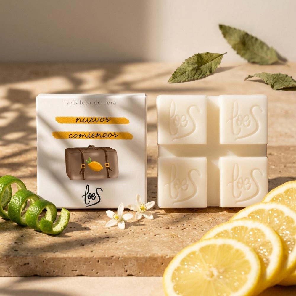 Tartaleta de cera perfumada Nuevos Comienzos LoeS con caja sobre travertino, limones frescos, piel de lima y flores de azahar – D'Arome