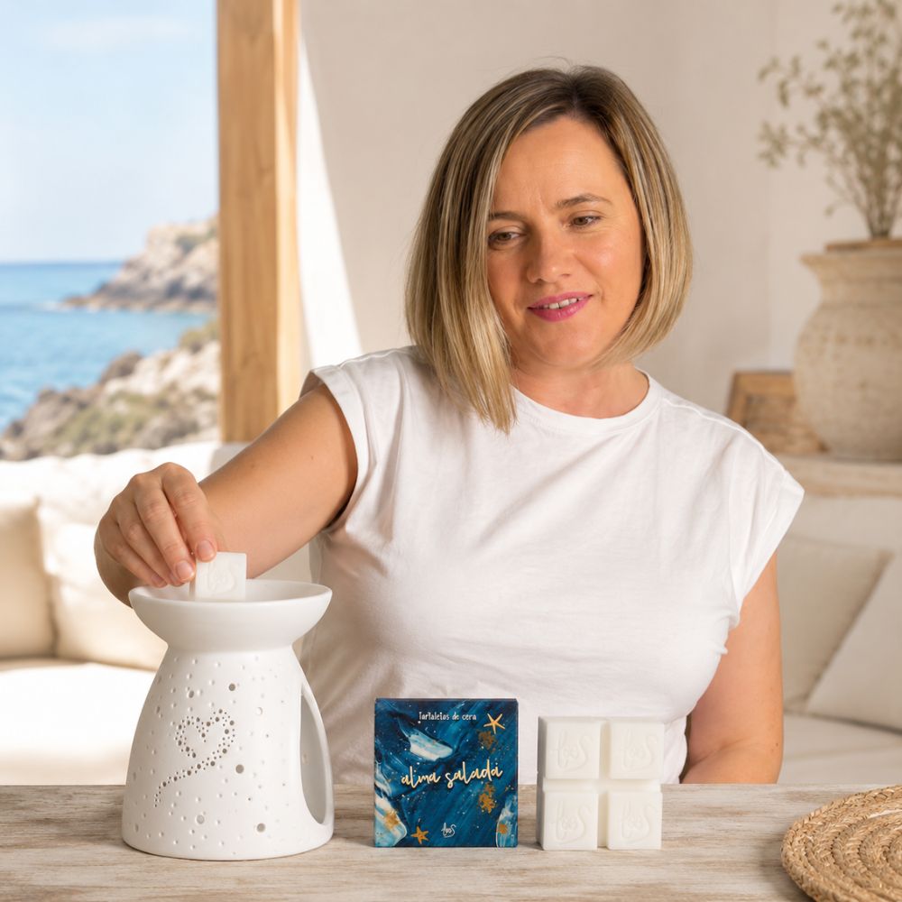 Ana Belén, cofundadora de D'Arome, coloca una tartaleta de cera Alma Salada de LoeS en el quemador en una terraza con vistas al mar Mediterráneo – D'Arome