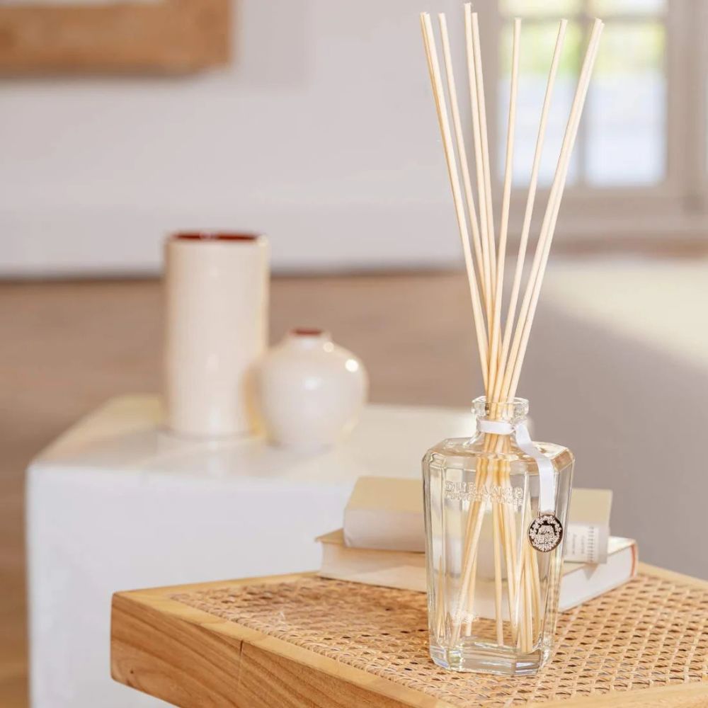 Varillas de rattan Durance colocadas en mikado bouquet parfumé sobre mesa nido de ratán en salón luminoso – D'Arome