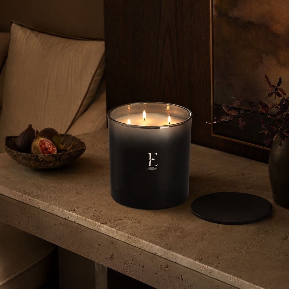 Vela aromática Figue Noire Edición Premium Esteban París encendida con sus tres mechas junto a higos frescos – D'Arome