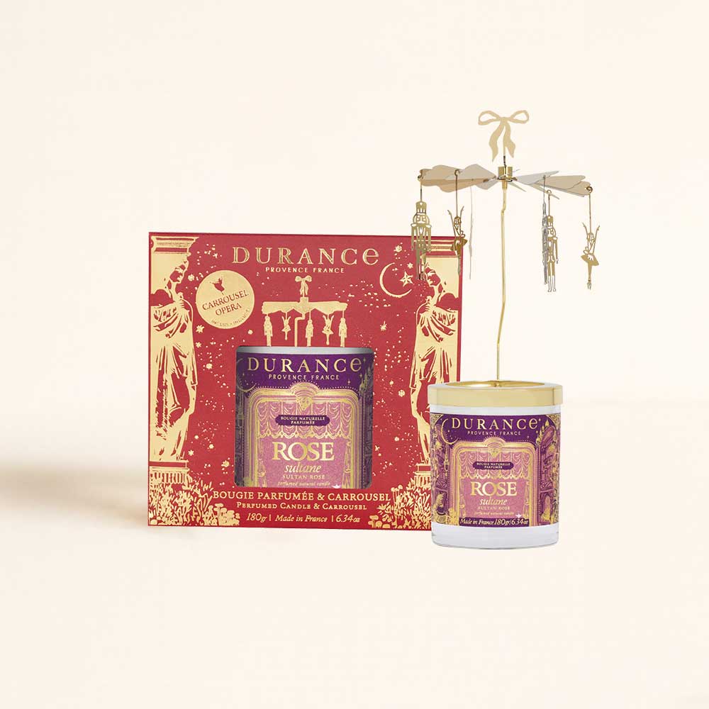 Vela Rose Sultane Durance 180g con carrusel giratorio dorado de bailarinas y soldaditos, junto a su caja que se activa cuando la vela se enciende – D'Arome