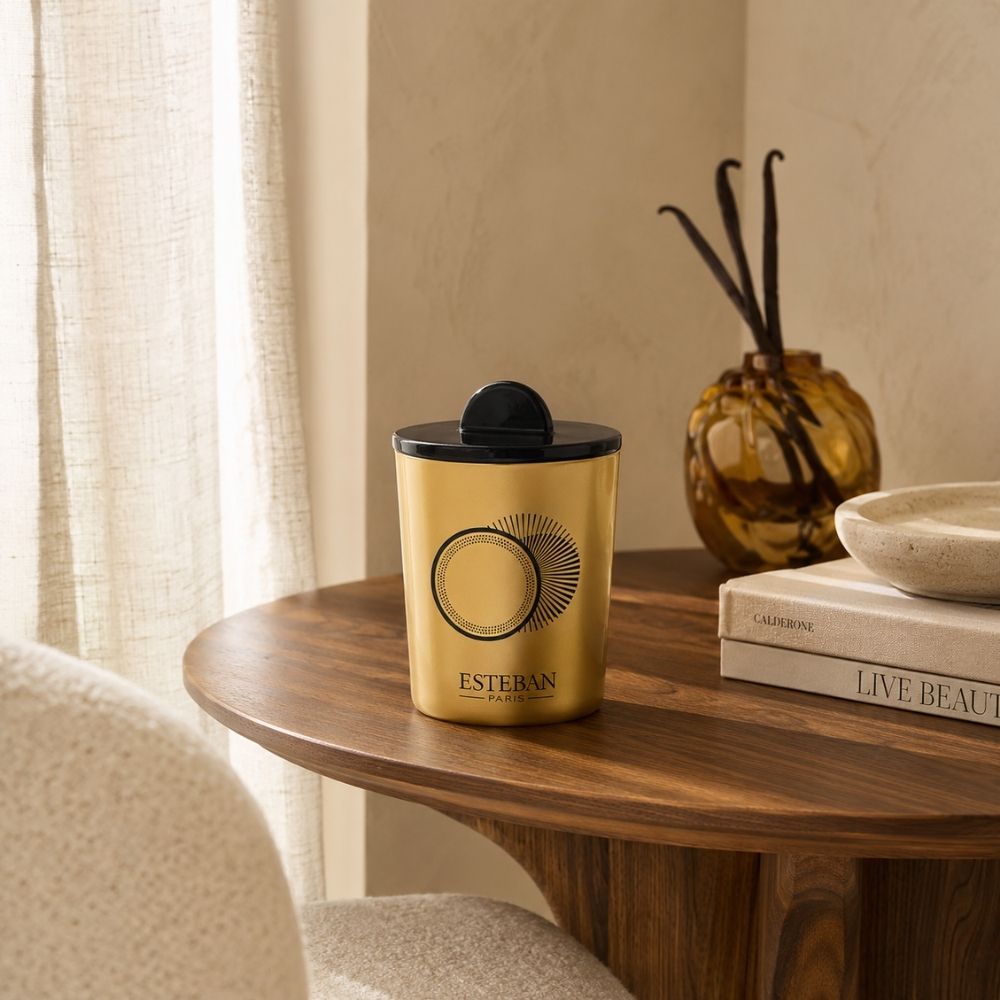 Vela decorativa perfumada recargable Ambre et Vanille Étoilée Esteban París sobre mesa de madera – D'Arome