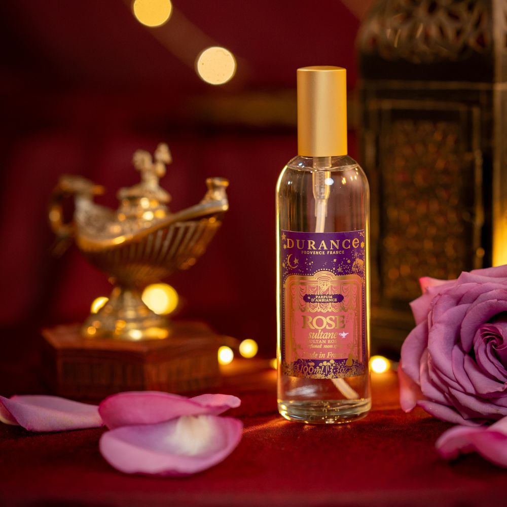 Vela perfumada Rosa Sultana 180gr de Durance encendida junto a rosa fresca y lámpara árabe dorada tipo Aladino, ambientación oriental Mil y Una Noches – D'Arome